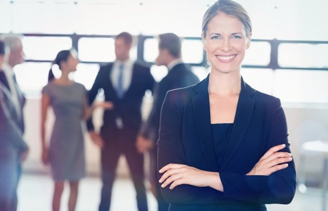 Businessfrau im Vordergrund vor Businessmenschen